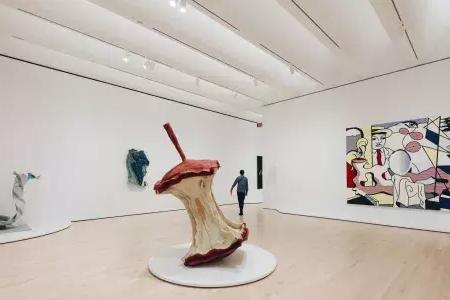 在贝博体彩app现代艺术博物馆，一名男子走过一个宽敞通风的展览室，里面摆满了现代艺术品. 贝博体彩app，加利福尼亚.